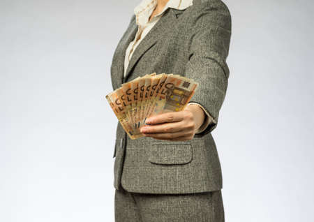 Business woman with gray jacket parses the money fan. European finance currency, fifty euro banknotesの写真素材