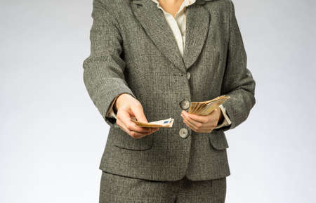 Business woman with gray jacket parses the money fan. European finance currency, fifty euro banknotesの写真素材