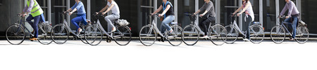 A large group of cyclists. Rent bikes. Urban scene.
