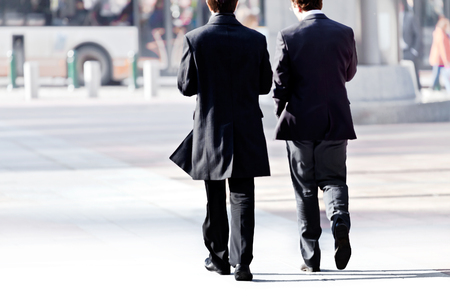 Two businessman walking conversing. Agreement. Urban scene.の写真素材