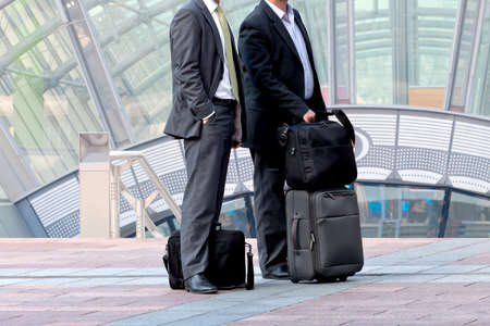 Two businessman with a business luggage. Urban scene.の写真素材