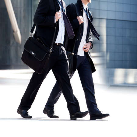 Two businessmen walking on the background of the office. Modern business people.