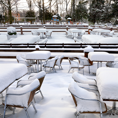 Cafe with snow. Winter landscaper. Garden furniture melting after a snowstorm.の写真素材