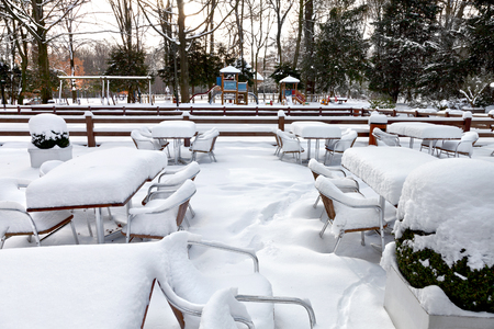 Cafe with snow. Winter landscaper. Garden furniture melting after a snowstorm.の写真素材