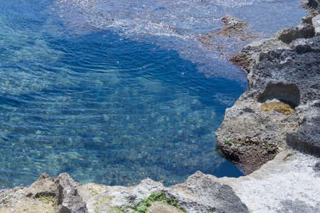 Natural pool of water on rocky beach  の写真素材