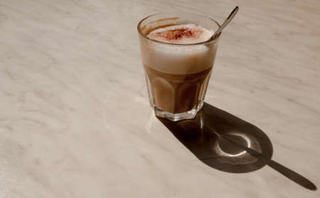 Glass with latte and spoonの写真素材