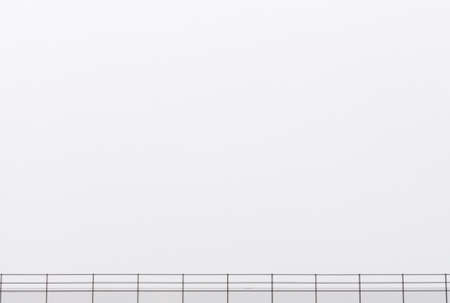 Subway track fence and grey skyの写真素材