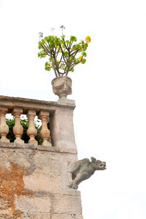 Gargoyle in the corner of a building in rural Majorca, isolated on white の写真素材