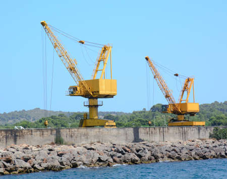 Two yellow industrial cranes on a jettyの写真素材