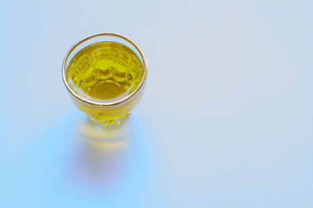 Golden olive oil in shot glass with copy space 