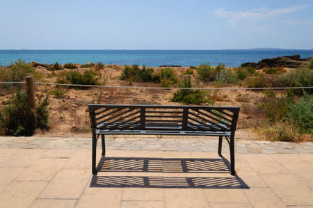 Park bench by the Mediterranean ocean, Majorca, Spain  Copa del Rei regatta in the bay の写真素材