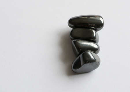 Four magnetite stones together on a white gray paper background の写真素材