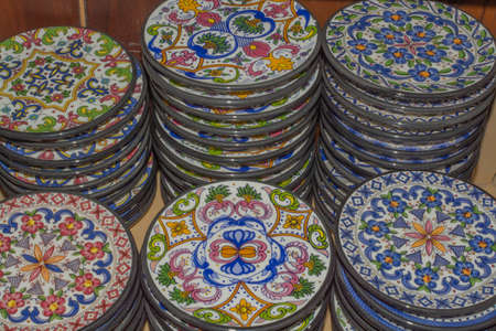 Small colorful plates of stoneware stacked in a store の写真素材