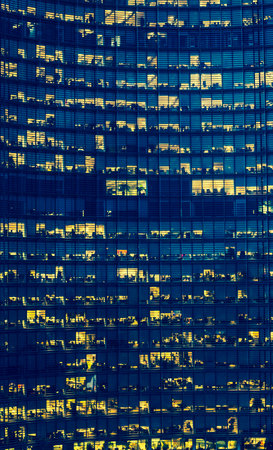 High Rise Office Building with many floors and visible but anonymous people at dusk 