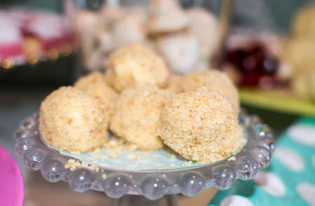 Cheesecake balls on green dotted paper and glass cakeplate, selective focus 