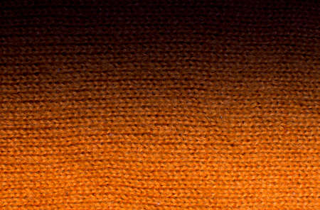 Orange wool knitwork fade to black  Orange wool knitwork full frame for warming backdrop or background の写真素材
