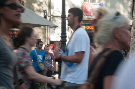 La Rambla crowd. People walking on La Rambla. The FC Barcelona flag is visible on a balcony....