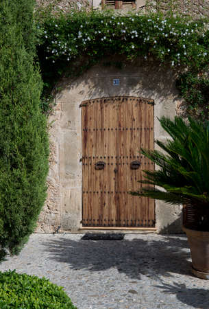 POLLENSA, MAJORCA, SPAIN - OCTOBER 28 2013: Pretty front door seen from the Calvary steps, Pollensa on October 28 2013 in Pollensa, Mallorca, Balearic islands, Spain.のeditorial素材