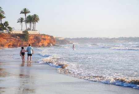 Retired couple on a morning walk on La Zenia beach on July 24 2012. La Zenia, Orihuela, Spain.のeditorial素材