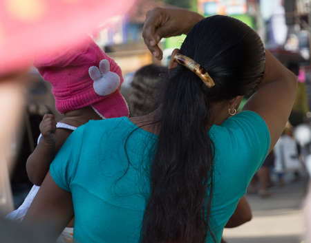 TANGALLE, SOUTHERN PROVINCE, SRI LANKA - DECEMBER 15, 2014: Woman and baby. Street view in Tangalle on December 15 2014 in Tangalle, Southern Province, Sri Lanka, Asia.のeditorial素材