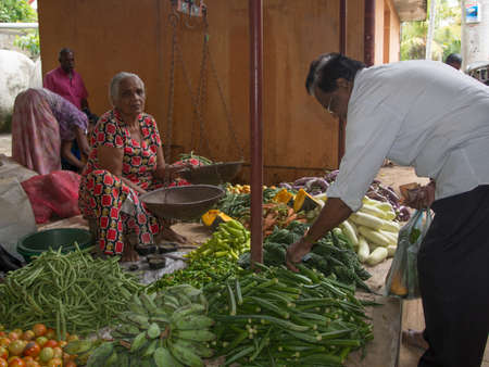 TANGALLE, SOUTHERN PROVINCE, SRI LANKA - DECEMBER 17, 2014: Vegetable vendor in the market on December 17, 2014 in Tangalle, Southern Province, Sri Lanka, Asia.のeditorial素材