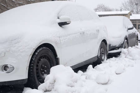 Parked cars in snowy weather on a suburb street in Vallingbyy, Stockholm, Sweden in January.の写真素材