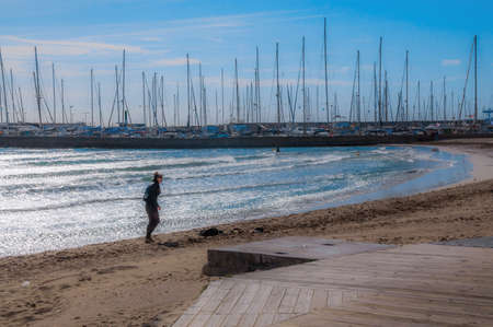 CAN PASTILLA, MAJORCA, SPAIN - FEBRUARY 10 2013: Surfer girl on  sunny winter beach on February 10, 2013 in Can Pastilla, Majorca, Spain.のeditorial素材
