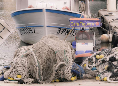 CALA FIGUERA, MAJORCA, SPAIN - NOVEMBER 2, 2013:  Fishnets and moored fishing boat with sign in port of Cala Figuera on November 2 2013, Mallorca, Balearic islands, Spain.のeditorial素材