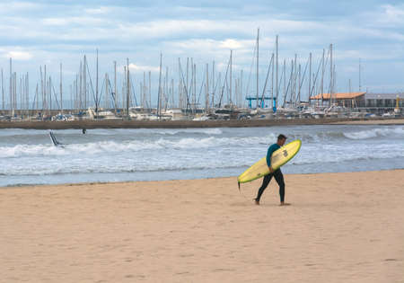 CAN PASTILLA, MAJORCA, SPAIN - NOVEMBER 5, 2013: Surfer with board on the beach on November 5, 2013 in Can Pastilla, Mallorca, Balearic islands, Spain.のeditorial素材