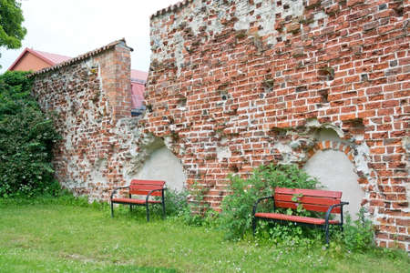 Red benches by medieval 13th century brick ruin, Ahus, South Sweden.の写真素材