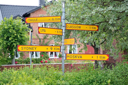 AHUS, SWEDEN - JULY 3, 2014: Humorous signs pointing out time difference to Thule, Glasgow, Bern, Moscow and Sydney  on July 3, 2014 in Ahus, Sweden.のeditorial素材