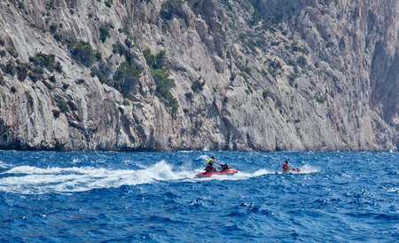 MALLORCA, BALEARIC ISLANDS, SPAIN - JULY 19, 2014: Jetskiers  speeding in seaspray on July 19 2014 in southwestern Mallorca, Balearic islands, Spain.のeditorial素材