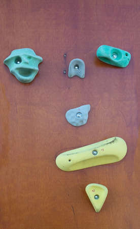 Manmade rock climbing wall with colorful knobs outdoors closeup.の写真素材