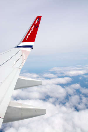 AIRBORNE, ALPES, FRANCE - APRIL 24, 2015: Norwegian airliner wing and the snow clad French Alpes below on April 24, 2015 in the air, French Alpes, France.のeditorial素材