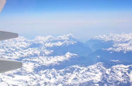 AIRBORNE, ALPES, FRANCE - APRIL 24, 2015: Airliner wing detail and snow clad French Alpes below on April 24, 2015 in the air, French Alpes, France.のeditorial素材