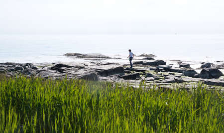 FALKENBERG, SWEDEN - JUNE 6, 2015: Boy crabfishing with net on the beach on June 6, 2015 in Skrea,...