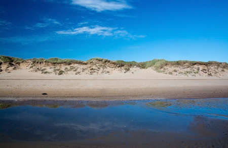 Sand dunes landscape with water and blue sky in Falkenberg Sweden.の写真素材