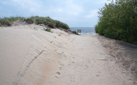 Pedestrian beach boardwalk with sand and sky in Halland Sweden.の写真素材