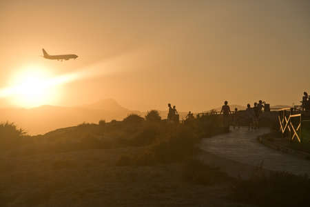 CAN PASTILLA, MAJORCA - JULY 21, 2014: People enjoy airplane spotting in golden sunset skies in a sunny summer evening in Es Carnatge on July 21, 2014 in Can Pastilla, Majorca, Spain.のeditorial素材