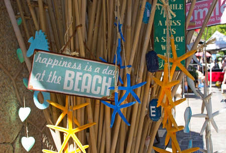 VALLDEMOSSA, MAJORCA, SPAIN - JULY 24, 2015: Happiness is a day at the beach metal sign and marine star decorations on display in a store at the Artdemossa festival in a sunny afternoon on July 24, 2015 in Valldemossa, Mallorca, Balearic islands, Spain.のeditorial素材