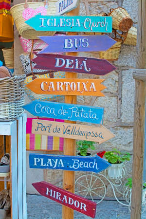 VALLDEMOSSA, MAJORCA, SPAIN - JULY 24, 2015: Valldemossa wooden colorful street signs with typical local attractions at the Artdemossa festival in a sunny afternoon on July 24, 2015 in Valldemossa, Mallorca, Balearic islands, Spain.のeditorial素材