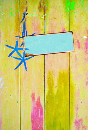 Yellow colorful vintage background with shabby distressed grungy texture hippie style, blue starfish and turquoise metal plate for text message.の写真素材