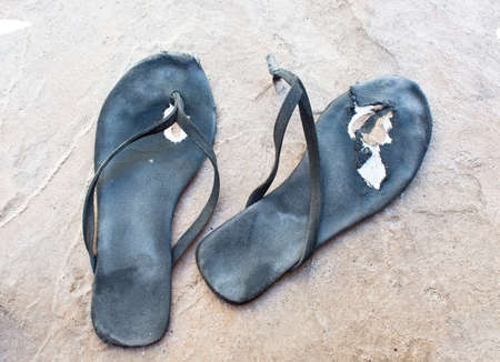 Flipflops torn distressed used and broken in black.の写真素材
