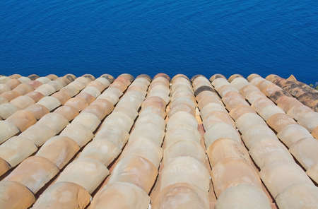 Roof tile and ocean background in Mallorca, Balearic islands, Spain in July.の写真素材