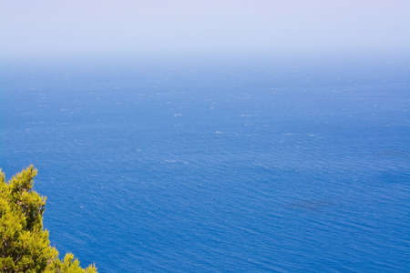 Mediterranean ocean with seafoam on a sunny windy day in Mallorca, Balearic islands, Spain in July.の写真素材