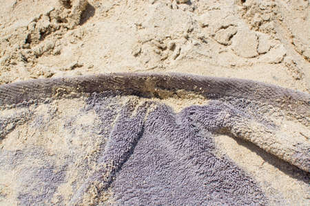Brown terrycloth towel in fine beach sand background.の写真素材