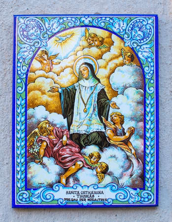 VALLDEMOSSA, MAJORCA, SPAIN - JULY 24, 2015: Decorative and religious wall tile with Valldemossa protector Saint Catherine, Sancta Catharina Thomas on a wall on July 24, 2015 in Valldemossa, Mallorca, Balearic islands, Spain.のeditorial素材