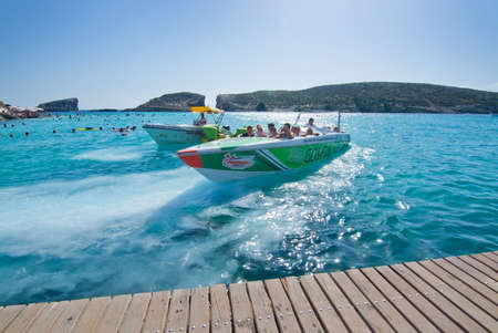 BLUE LAGOON, COMINO, MALTA - SEPTEMBER 16, 2015: Boats in the clear turquoise water of popular...