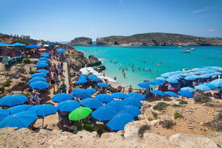 BLUE LAGOON, COMINO, MALTA - SEPTEMBER 16, 2015: Visitors crowd to enjoy the clear turquoise water...