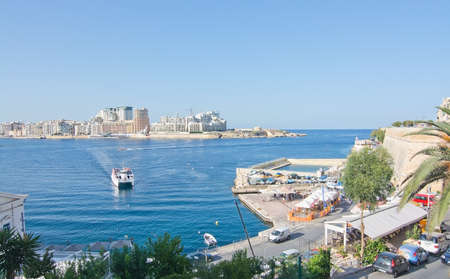 SLIEMA, MALTA - SEPTEMBER 15, 2015: Sliema skyline and ferry en route from Sliema to Valletta ferry...